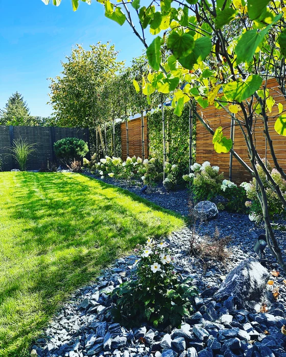 Piscine rectangulaire extérieure aux eaux turquoise, entourée d'une terrasse en lames de bois composite brun foncé