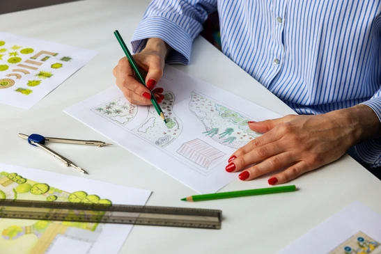 Plan d'am&eacute;nagement paysager color&eacute; sur table de travail avec instruments de dessin technique