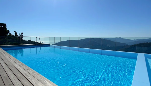 Piscine ext&eacute;rieure luxueuse avec cascade d&eacute;corative int&eacute;gr&eacute;e dans un mur en pierre naturelle