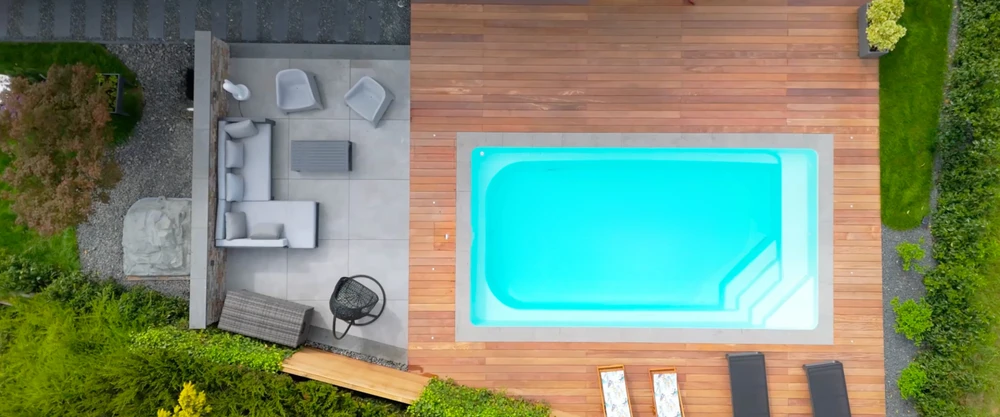 Jardin paysager contemporain extérieur, terrasse en lame de bois composite foncé, bordure en bois exotique teinté avec bassin décoratif en granit noir