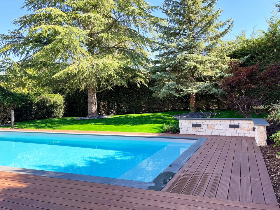 Bassin bleu et gris carrelé par un technicien dans une piscine en construction